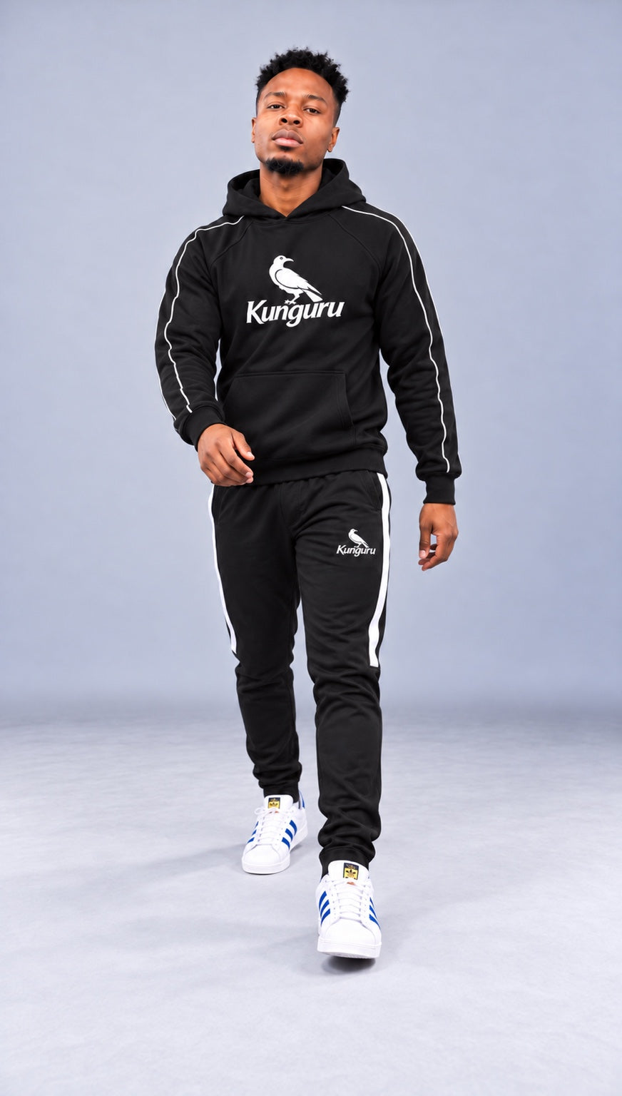 Model wearing black Kunguru Hoodie and Kunguru Track Pants — studio view 1