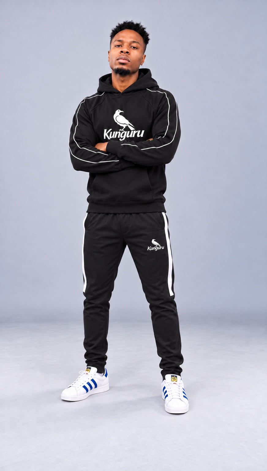 Model wearing black Kunguru Hoodie and Kunguru Track Pants — studio view 2